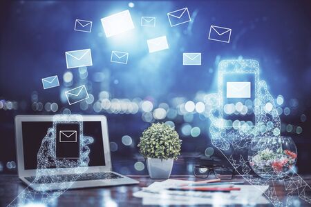 Desktop computer background in office and flying envelops hologram drawing. Multi exposure. Electronic mail concept.の写真素材
