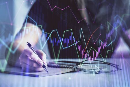 Multi exposure of woman's hands making notes with forex graph hologram. Concept of technical...