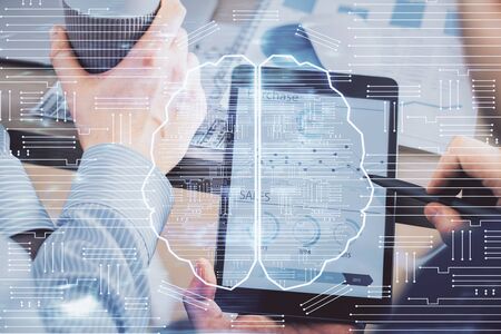 Double exposure of man's hand holding and using a digital device and brain hologram drawing. Data concept.の写真素材