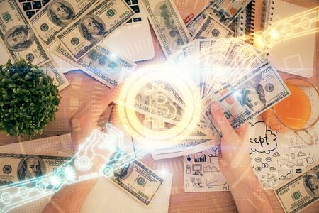 Multi exposure of blockchain theme drawing hologram and USA dollars bills and man hands. Business...