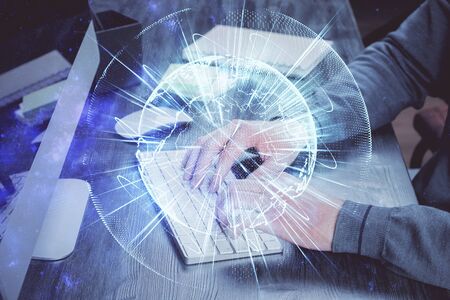 Double exposure of businessman working on laptop on background. International business hologram in front. Concept of success.の写真素材