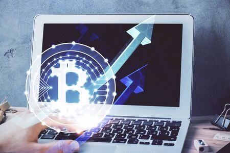 Crypto currency theme hologram with businessman working on computer on background. Concept of...
