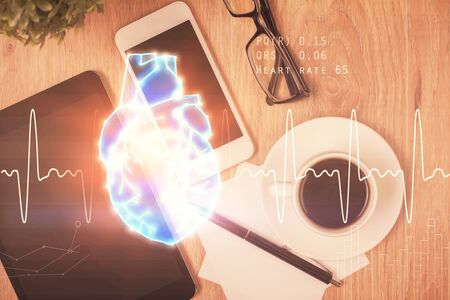 Double exposure of heart drawing over table with phone. Top view. Medical education concept.の写真素材