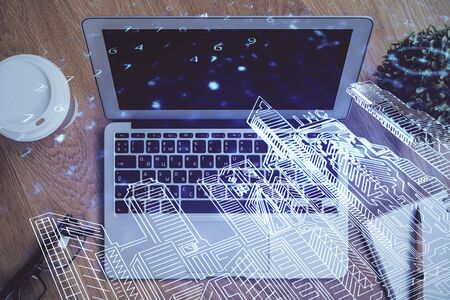 Desktop computer background in office and big town buildings hologram drawing. Double exposure. Smart city concept.の写真素材