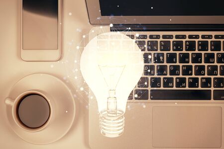 Bulb drawing over computer on the desktop background. Top view. Double exposure. Idea concept.の写真素材