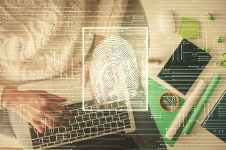 Double exposure of woman hands working on computer and fingerprint hologram drawing. Top View....