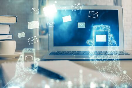 Desktop computer background in office and flying envelops hologram drawing. Multi exposure. Electronic mail concept.の写真素材