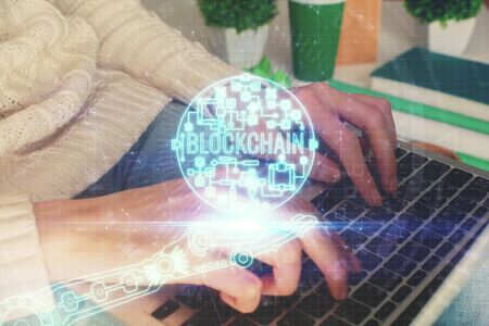 Double exposure of woman hands typing on computer and crypto market theme hologram drawing. Blockchain concept.の写真素材