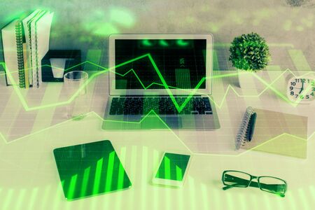 Forex market graph hologram and personal computer on background. Double exposure. Concept of investment.の写真素材