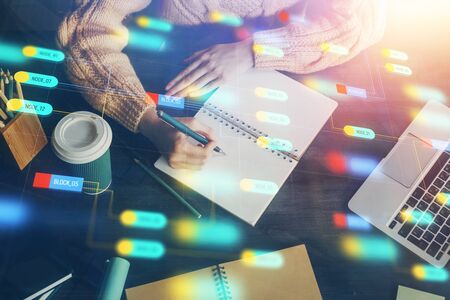 Double exposure of writing hands on background with data solution hologram on front. Technology...