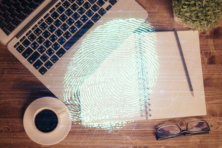 Finger print over computer on the desktop background. Top view. Double exposure. Concept of securitization.の写真素材