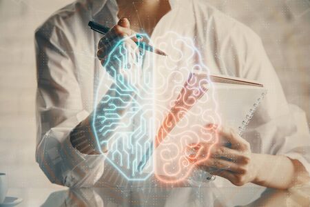 Multi exposure of writing hand on background with brain hologram. Concept of self learning.の写真素材