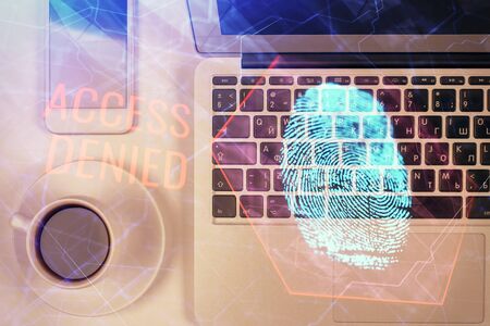 Finger print over computer on the desktop background. Top view. Double exposure. Concept of securitization.の写真素材