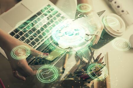 Double exposure of woman hands typing on computer and social network theme hologram drawing. People...