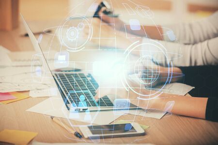 Double exposure of woman hands typing on computer and social network theme hologram drawing. People...