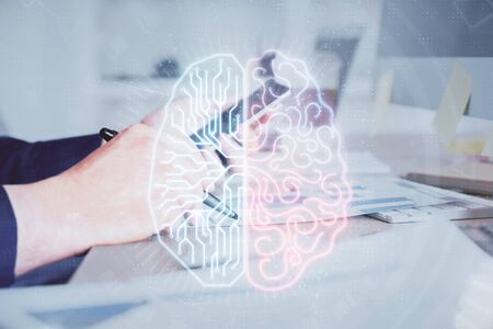 Double exposure of mans hand holding and using a digital device and brain hologram drawing. Data concept.の写真素材