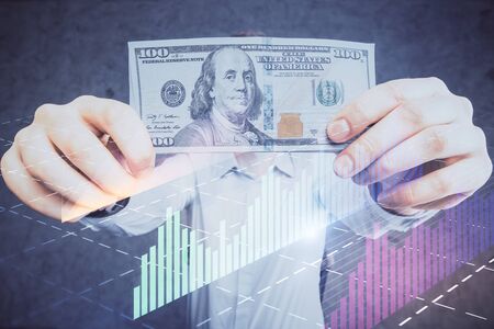 Multi exposure of financial graph drawing hologram and USA dollars bills and man hands. Analysis concept.の写真素材