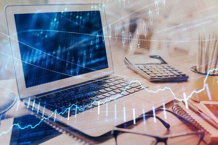 Stock market graph on background with desk and personal computer. Multi exposure. Concept of...