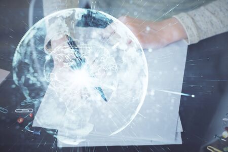 International business hologram over womans hands taking notes background. Concept of success. Double exposureの写真素材