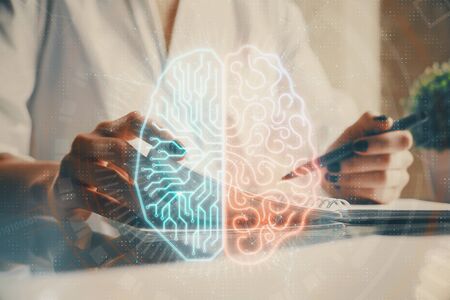 Multi exposure of writing hand on background with brain hologram. Concept of self learning.の写真素材
