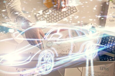 Double exposure of man's hands typing over computer keyboard and automobile theme hologram drawing....