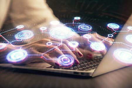 Double exposure of woman hands typing on computer and social network theme hologram drawing. People...