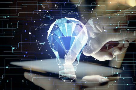 Double exposure of man's hands holding and using a digital device and bulb hologram drawing. Idea concept.の写真素材