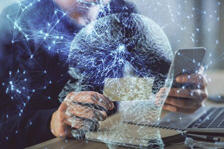 Double exposure of mans hand holding and using a digital device and brain hologram drawing. Data concept.の写真素材