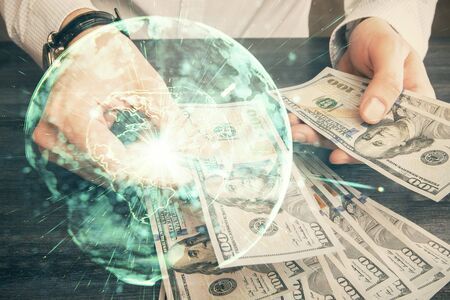 Multi exposure of financial theme drawing hologram and USA dollars bills and man hands. Business concept.の写真素材