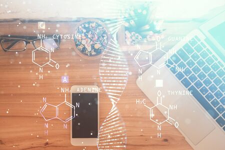 Double exposure of DNA drawing over table with phone. Top view. Science education concept.