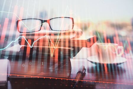Financial graph hologram with glasses on the table background. Concept of business. Double exposure.の写真素材