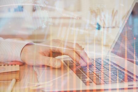 Double exposure of stock market graph with man working on laptop on background. Concept of financial analysis.の写真素材
