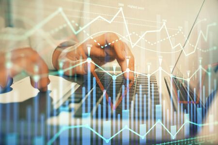 Double exposure of market chart with man working on computer on background. Concept of financial...