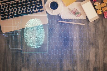 Finger print over computer on the desktop background. Top view. Double exposure. Concept of securitization.の写真素材