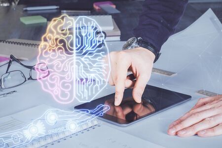 Double exposure of man's hand holding and using a digital device and brain hologram drawing. Data concept.の写真素材