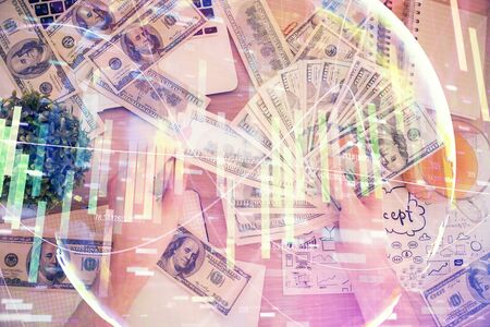 Multi exposure of financial theme drawing hologram and USA dollars bills and man hands. Business concept.の写真素材
