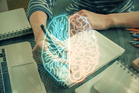 Multi exposure of writing hand on background with brain hologram. Concept of self learning.