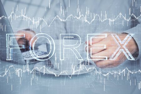 Double exposure of graph with man typing on computer in office on background. Concept of hard work.の写真素材