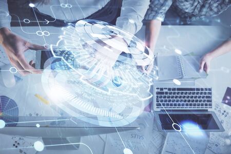 Double exposure of man and woman working together and data theme hologram drawing. Computer...