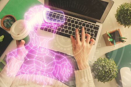 Double exposure of woman hands working on computer and man in ar glasses hologram drawing. Top View....