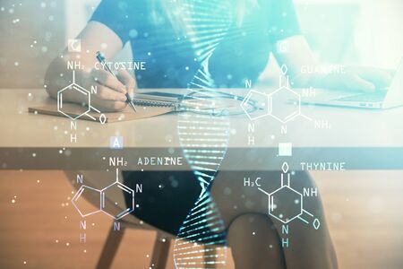Double exposure of woman hands typing on computer and DNA hologram drawing. Medical education concept.の写真素材