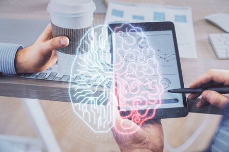 Double exposure of mans hand holding and using a digital device and brain hologram drawing. Data concept.の写真素材