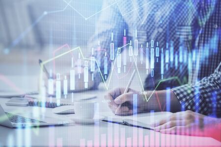 Multi exposure of forex chart with man working on computer on background. Concept of market...