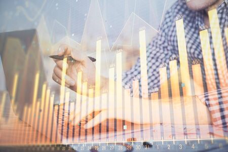 Multi exposure of forex graph with man working on computer on background. Concept of market analysis.の写真素材