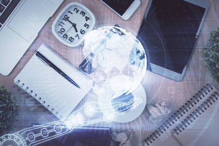 Double exposure of map hologram drawing over desktop. Top view. International connection concept.