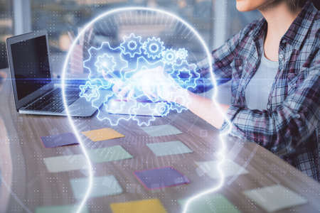 Multi exposure of woman hands working on computer and human brain hologram drawing. Ai tech concept.