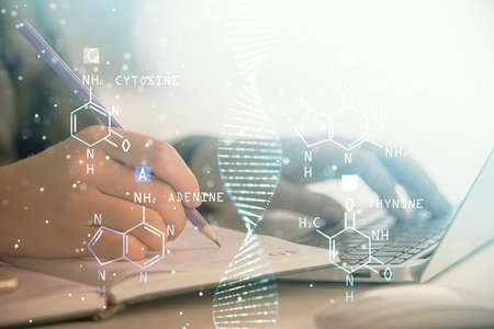 Double exposure of woman hands typing on computer and DNA hologram drawing. Medical education...