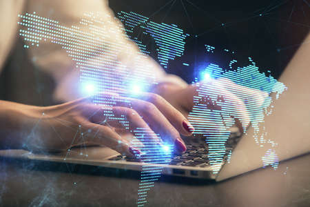 Double exposure of woman hands typing on computer and social network theme hologram drawing. People...