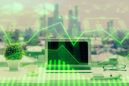 Forex Chart hologram on table with computer background. Multi exposure. Concept of financial markets.の写真素材