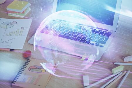 Computer on desktop in office with technology theme hologram. Multi exposure. Tech concept.の写真素材